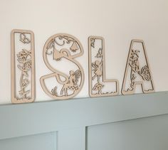 the letters are cut out of wood and placed on top of a shelf in front of a wall