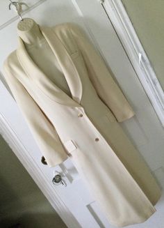 Ivory colored 2-button front 1990's vintage 3/4 length blazer/jacket, made in Franc, is by LOUIS FERAUD. This blazer/jacket is a 3/4 length, hitting mid-calf, is lined in silk, which has the 'Louis Feraud' name embossed all over the silk fabric (photo 6). The outer or shell fabric is a textured worsted wool (photo 7) Long shawl lapel, 2 goldtone buttons at the front placket for closure. Welt pocket at the right breast and 2 flap pockets at the right and left hip area. Long barrel sleeves, princess seams in the front and side back. The back has a decorative buttoned martingale band (photo 5). Coloring is a creamy ivory...like a vanilla. This long jacket/blazer was made in the 1990's in FRANCE. Size tag is missing; I estimated the size based on the measurements, to be a size 4. There's a tin Classic Cream Single-breasted Blazer, Cream Lapel Collar Blazer With Single Button, Classic Cream Double-breasted Blazer, Cream Blazer With Single Button And Lapel Collar, Cream Single Button Blazer With Lapel Collar, Classic Cream Blazer With Button Closure, Cream Outerwear With Double Button And Notch Lapel, Cream Blazer With Button Closure And Lapel Collar, Classic White Long Outerwear