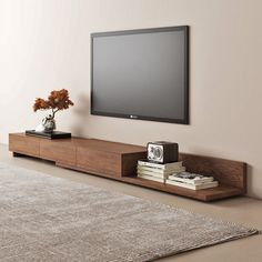 a flat screen tv mounted to the side of a wooden entertainment center in a living room