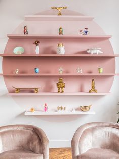 pink shelves with figurines on them in a living room