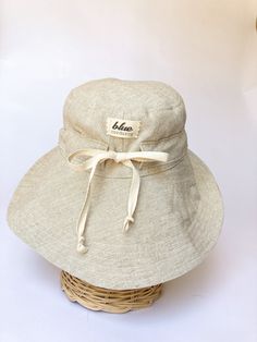 "A sun hat for beach days and summer fun. This sun hat for women has a nice wide brim to protect your whole face and even your neck and chest. A drawstring around the head keeps the hat fitting snug. Easy to bring along in your bag, folds up easy. This hat is made from a medium weight homespun linen and cotton blend fabric in a neutral beige color. Inside liner is white cotton. I used a stiff interfacing for brim to keep it's shape. Brim measures 4.5\" Crown depth is 3.5\". Contact me for custom Adjustable Brimmed Bucket Hat For Beach Season, Lightweight Bucket Hat With Curved Brim For Sunbathing, Lightweight Natural Sun Hat For Sunbathing, Beachy Cream Sun Hat For Vacation, Adjustable Cotton Hat For The Beach, Adjustable Sun Hat With Upf 50+ For Summer, Adjustable Cotton Beach Hat, Adjustable White Bucket Hat For The Beach, Adjustable White Bucket Hat For Beach