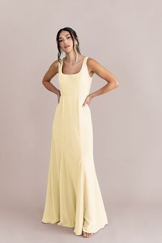 a woman in a yellow dress posing for the camera with her hands on her hips