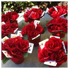 many red roses are sitting on top of cards and playing cards in the middle of them