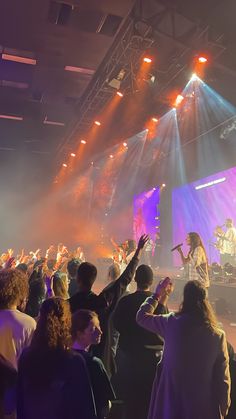 a group of people standing on top of a stage next to each other in front of a crowd