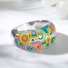 A bold ring features bright enamel colors in a geometric design, accented by sparkling white stones. A modern take on the classic design, this ring features bold enamel coloring, creating a bold, eye-catching design that looks fantastic wherever it is worn.  If you are looking for something simply gorgeous, this geometric painted ring is the perfect answer.Carat Weight: 0.14 ctStone Size: 1 mmStone Type: Jeulia® StoneNumber of Stones: 14 Stone Shape: RoundStone Color: Diamond WhiteWeight: 6.34 g Jewelry 2024, Enamel Rings, Funky Rings, Math Game, Bold Rings, White Stones, Funky Jewelry, Enamel Ring, Jewellery Design