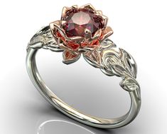 "This amazing engagement ring positively radiates beauty and strength. With its vibrant colors and lovely floral design, it's sure to be a conversation starter. Choose this piece of fine jewelry for someone with a unique spirit. The narrow band is created from gleaming, 14kt white gold, with a symmetrical design of white gold leaves at the top, which surround a beautiful lotus flower crafted from warm rose gold. At the very center sits a glistening, vivid ruby. ★See A Video Of This Amazing Ring Luxury Ruby Flower Ring In Elegant Style, Luxury Ruby Flower Ring, Elegant Style, Flower Ruby Rings, Red Rose Wedding Ring, Cheap Elegant Rose Rings, Luxury Red Elegant Flower Ring, Witchy Wedding Rings Ruby, Wanda And Vision Wedding Rings, Luxury Ruby Flower Ring For Wedding