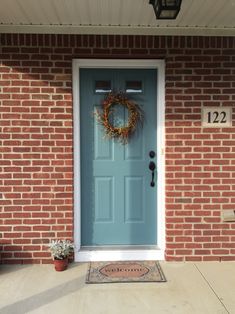 a blue front door with a wreath on it