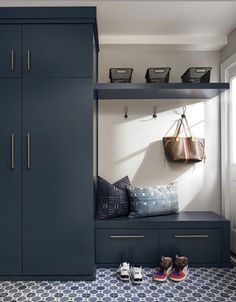 an entryway with blue cabinets and shoes on the floor