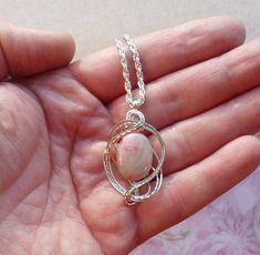 This pink peruvian opal necklace pendant is wire wrapped in silver and completely handmade by me. This is my own original design and is entirely unique. If you are looking for something eye catching and one of a kind I can guarantee that you will not see similar piece anywhere unless it's also one of mine! Please note that the stone pictured is a sample only, yours will be the same color, size and shape but there will be some natural variations. About the Stone: The stones I use in this design a Silver Opal Wire Wrapped Necklace, Handmade Pink Opal Round Jewelry, Handmade Round Pink Opal Jewelry, Handmade Pink Opal Jewelry Gift, Handmade Pink Opal Pendant Necklace, Handmade Pink Opal Spiritual Jewelry, Wire Wrapped Opal Pendant Necklace, Pink Opal Jewelry Gift, Unique Pink Opal Jewelry For Gifts