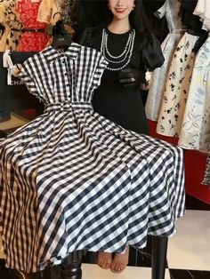 This elegant dress features slight stretch fabric and a slim fit silhouette, making it ideal for the office or a summer event. The design includes a polo collar, high waist, and A-line shape, all made from polyester with a plaid pattern. It has short sleeves, a mid-calf length, and a belt for decoration. This sophisticated dress is perfect for women looking for a stylish and comfortable option, and is made from synthetic fibers in China. The dress also has a single-breasted closure, an empire waistline, and a release date of Summer 2024. Knee-length Shirt Dress For Summer Evenings, Summer Evening Knee-length Shirt Dress, Black A-line Shirt Dress, Collared Shirt Dress For Summer, Black Collared Shirt Dress For Summer, Black Shirt Dress For Summer Party, Summer Party Black Shirt Dress, Classic Summer Dress With Collared Neckline, Classic Summer Shirt Dress For Office