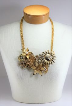 "Vintage Gold Flowers Pearls Rhinestone Metal Assemblage Statement Bib Necklace Handcrafted OOAK. Year around there are always weddings and parties to attend. So I got busy making this wonderful handcrafted necklace blooming with reclaimed vintage gold metal flower pins and other vintage pieces, including pearls and rhinestones, to make this eye catching statement necklace. Vintage gold tone link necklace doubled for added flair! Total drop of necklace is 13\" to bottom of flowers at longest len Gold Embellished Wedding Jewelry, Gold Embellished Evening Necklaces, Gold Embellished Evening Necklace, Gold Jeweled Bridal Necklace For Party, Gold Crystal Bridal Necklace For Celebrations, Glamorous Gold Bridal Necklace For Party, Gold Rhinestone Crystal Necklace For Celebration, Party Costume Jewelry Bridal Necklace, Gold Bridal Necklace With Bling As Gift