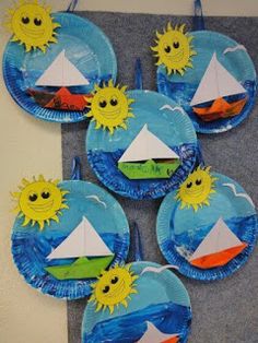 paper plates with boats and sun on them are arranged to look like they're floating in the water