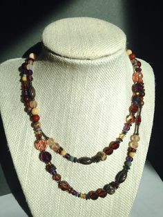 "30 inch necklace. Austrian crystal and Czechoslovakian glass in shades of smoke topaz, amethyst, and light peach. Tiger Jasper semi-precious gemstone accents. Many of the beads are rare and irreplaceable, circa 1920-1930. Trim is antiqued bronze, from our own tooling. \"Rinky Dinky Parlez-Vous\" necklace is handmade in the USA. Owen Glass Collection jewelry is ready for gift-giving, with an organza bag and description card included. Please let us know if you would like us to make a matching bra Art Deco Necklace, Light Peach, Matching Bracelets, Austrian Crystal, Metallic Accents, Earth Tones, Semi Precious Gemstones, Glass Collection, Antique Bronze