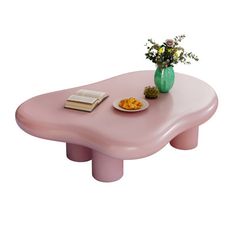 a pink coffee table with flowers and a book on it