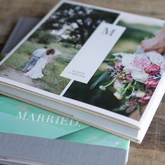 two books stacked on top of each other with pictures in the pages and one being held by someone's hand