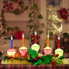 three lit candles sitting on top of a table next to a christmas wreath and other decorations