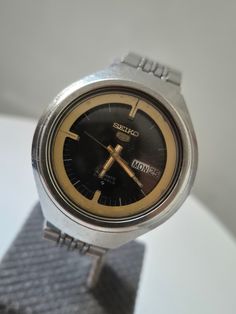 Rare Seiko 5 Automatic Cal.  6319-7010,  1970's Vintage Japan Made Men's Watch,Rare Brown Dial,Daydate Helmet Case,Rare Collection Wristwatches,All Original  Rare and Beautiful Seiko Day Date Automatic Men's Watch. 6319 Automatic movement. Ufo design. Inner bezel in different color. From 1970's. Case: 39.2 mm ( without crown) Bracelet: 18 cm, Stainless Steel. Movement: Seiko Automatic 6319. It works good. Condition - In overall good vintage condition with no major flaw beautifully aged ,not poli Retro Automatic Watch With Round Dial, Vintage Black Collectible Watch, Retro Analog Watch For Anniversary, Retro Automatic Watch Accessories For Anniversary, Retro Analog-style Collectible Watch Accessories, Vintage Silver Chronograph Watch With Date Display, Vintage Chronograph Watch With Round Dial, Vintage Chronograph Watch With Date Display, Retro Automatic Collectible Watches