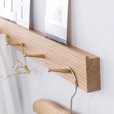 a coat rack with clothes hangers on it next to a wall mounted photo frame