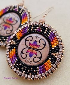 the earrings are decorated with colorful beads and bead work on it's sides