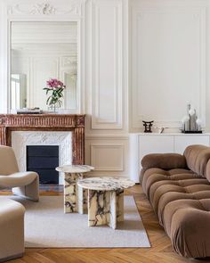 a living room filled with furniture and a fire place next to a mirror on the wall