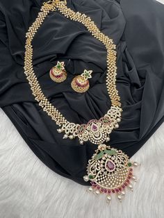 AD Red Green Multi Stone Peacock Pendent Golden Finish Long Necklace comes with Jhumkis Party wear golden finish American diamonds multi Color Necklace Pair it up with Saree Lehenga aur any Party wear dress. Necklace Length : Approx. 22 inches; Comes with adjustable back chain. Earring Length : .2 Inches Screw Back Ready to ship from Massachusetts, USA If you have any questions, Please let me know. Thank you!! Festive Kundan Necklace With Zari Work For Parties, Festive Kundan Necklace With Peacock Design For Wedding, Temple Jewelry With Zari Work For Party, Festive Jewelry Set With Zari Work, Gold Kundan Necklace With Peacock Design For Celebration, Gold Kundan Necklace With Zari Work In Anarkali Style, Kundan Temple Jewelry Necklace For Parties And Festivals, Heavy Necklaces For Navratri Party, Heavy Kundan Temple Necklace For Party