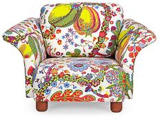 an upholstered chair with colorful designs on it's arms and back legs