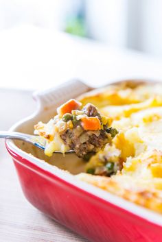 a casserole dish with meat, vegetables and cheese in it on a table