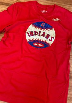 a red t - shirt with the word indiana on it and a baseball in the center