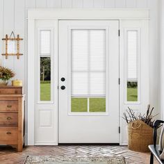 a white front door with blinds on the side and an area rug in front of it