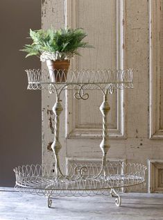 two tiered trays with plants in them on top of a wooden table next to a door