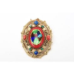 This is part of Chairish’s Costume Jewelry assortment.  This vintage set of signed Hattie Carnegie enamel clip on earrings and small pin and or pendant is reminiscent of a bygone era of Elizabethan meets byzantine influence. The colors are rich, vibrant and exquisite as are all the details and workmanship. They range from the enamel work of red, royal blue, iridescent blue and green.The rhinestones are green and the glass is red and blue. The play of colors used and the high quality of the ename Vintage Enamel Jewelry For Collectors, Vintage Enamel Jewelry With Vintage Charm, Vintage Enamel Collectible Jewelry, Party Jewelry With Jeweled Enamel, Collectible Multicolor Costume Jewelry Brooches, Multicolor Cabochon Costume Jewelry, Antique Clip-on Jewelry For Parties, Antique Jeweled Brooches For Gifts, Formal Jeweled Enamel Jewelry