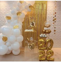 balloons and decorations in the shape of numbers are displayed on a table with gold foil