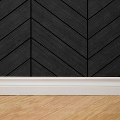 an empty room with wood flooring and black wallpaper