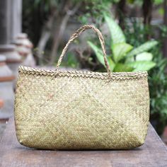 Add a natural look to your ensemble with this woven tote bag from Balinese artisan team Dewa Brother. Crafted from woven water hyacinth reeds the open-top bag features a woven pattern in a natural color two straps that fit comfortably over your shoulder and an open pocket. Eco-friendly Palm Leaf Bag With Open Weave, Rectangular Woven Natural Fiber Beach Bag, Natural Woven Rectangular Straw Bag, Rectangular Woven Natural Straw Bag, Woven Natural Fiber Straw Bag For Travel, Natural Fiber Woven Straw Travel Bag, Traditional Tote Bag With Bamboo Handle, Natural Fiber Straw Bag With Weaving For Travel, Rectangular Palm Leaf Beach Bag With Open Weave