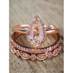 two wedding bands with an oval cut diamond in the center and a pear shaped morganite on each band