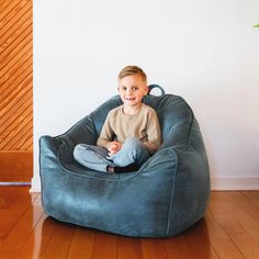 a young boy sitting in a bean bag chair