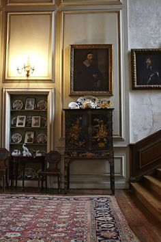 an ornately decorated room with paintings on the wall and antique furniture in the foreground