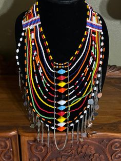 "Lovely colorful African handmade draping jewelry necklace. This is a bright and colorful ceremonial necklace, handmade on the Masai Mara in Kenya, Africa. It is a rainbow of bright colors, plus lots of dangling jingling silver charms which drape across the chest. Over 12 beautiful decorative strands of beads. There is just something about Africa that seeps into your soul and stays with you. I set out to paint Utah and all of its beauty...but my heart keeps returning to Africa again and again. I Colorful Beaded Dangle Necklaces, Yellow Beaded Necklaces With Large Beads For Festivals, Traditional Beaded Necklaces With Colorful Beads For Festival, Multicolor Necklace For Festival Gift, Beaded Jewelry Sets For Festivals, Bohemian Colorful Beads Jewelry For Festive Occasions, Multicolor Bohemian Beaded Necklaces With Dangle, Multicolor Dangle Beaded Necklaces In Bohemian Style, Multicolor Round Beaded Jewelry For Festivals