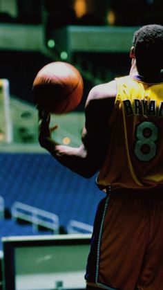 a man holding a basketball in his right hand and wearing a jersey with the number 8 on it