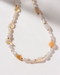 A twist on a classic styling, this necklace features lustrous freshwater pearls interspersed with iridescent opal beads. The combination of these two gems creates a harmonious blend of traditional and modern styles. Freshwater pearls symbolize purity, wisdom, and integrity, while opals are known for their emotional healing properties and ability to inspire creativity. Together, they create a necklace that is not only beautiful but also rich in meaning. Each pearl is individually picked for its l Elegant Adjustable Pearl Necklace With Gemstone Beads, Elegant Necklaces With Oval Natural Stones, Elegant Amber Beaded Necklace, Pearl White Necklaces With Natural Stones, Elegant Amber Single Strand Beaded Necklaces, Pearl White Necklace With Round Natural Stones, Elegant Amber Single Strand Beaded Necklace, Elegant Amber Beaded Single Strand Necklace, Elegant Amber Beaded Necklace With Gemstone Beads