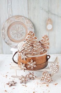 some cookies are sitting in a cookie tin on a table next to other treats and decorations