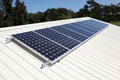 a solar panel on the roof of a house with trees in the backgroud