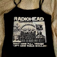 Radiohead Aesthetic Crop Top | Spaghetti Strap Baby Tee | Gothic Grungecore Fashion Show Your Love For Radiohead With This Stylish Band Tee Shirt Crop Top Featuring A Spaghetti Strap Design And Made From Stretchy Spandex, This Baby Tee Combines Comfort And Aesthetic Appeal. Perfect For Fans Of Gothic, Grungecore, Coquette And Punk Styles, This Versatile Top Is Ideal For Layering Or Wearing On Its Own To Showcase Your Unique Fashion Sense. #Radiohead #Bandtee #Croptop #Spaghettistrap #Gothfashion Summer Band Merch Top With Graphic Design, Summer Band Merch Tops With Graphic Design, Band Merch Tops With Graphic Design For Summer, Edgy Fitted Tops With Graphic Design, Spring Band Merch Tops With Graphic Design, Summer Concert Tops With Logo Print, Y2k Graphic Print Tops For Music Festival, Fitted Punk Tops With Graphic Design, Unisex Summer Tops With Graphic Design