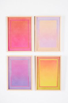 three square paintings on a white wall one is pink, the other is blue and yellow