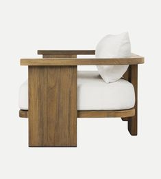 a wooden chair with white pillows on the back and arm rest in front of it