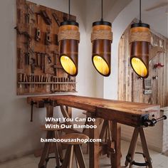 three lights hanging over a wooden table with stools