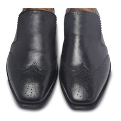 To find that perfect blend of smart casual in footwear, look no further than this pair of black brogue wingtip slip-on leather loafers. You can go sockless in them with jeans on a casual night out with friends or wear them with a trendy, sleek suit for a formal event. Wingtips are a brogue with details on the extended toecap that add a dash of personality to your attire. Slip into these easy to wear stylish shoes for casual or formal events to look more stylish than ever. Some of its features include: Slip-On Shoes Wingtip with Bull Brogue design Perforations and pinking on a top of shoe vamp The edges of the shoe back stay also have perforations and pinking Comfortable in-sole Available in classic black and tan tones, this leather footwear is a must-have for all tasteful fashion lovers ou Classic Black Slip-ons With Stitched Sole, Black Monk Strap Shoes With Brogue Detailing, Black Monk Strap Wingtip Shoes With Brogue Detailing, Black Wingtip Monk Strap Shoes With Brogue Detailing, Classic Black Slip-ons With Brogue Detailing, Casual Wingtip Slip-ons With Brogue Detailing, Black Cap Toe Semi-formal Loafers, Black Monk Strap Shoes With Wingtip And Rubber Sole, Black Wingtip Monk Strap Shoes With Rubber Sole