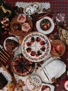 a table topped with lots of different types of food on plates and serving utensils