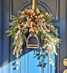 a blue door with a wreath hanging on it's side and a bell in the middle