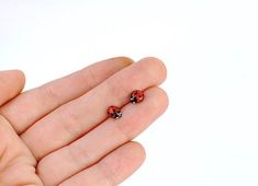 so cute and so realistic!tiny ladybug stud earringsjust the size of the real ladybugsterling silver post and a closure, a copper bug, coated with enamel (both sides, so the earring is non allergic)red enamel gets the most vibrant shade when combined with coppereach bug is hand painted with a tiny brush, each pair of earrings is unique Funky Stud Earrings, Ladybug Earring, Blueberry Emoji, Insect Earrings, Ladybug Earrings, Ladybug Jewelry, Unique Stud Earrings, Dope Jewelry Accessories, Earrings Piercings